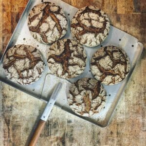 Vier Bio-BIO-SYLTER LICHTKORN-ROGGEN BROT auf einem Metalltablett mit einem Messer.