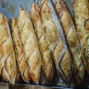 Ein Tablett mit Bio-Bio-Dinkel-Baguette auf einem Holztisch.