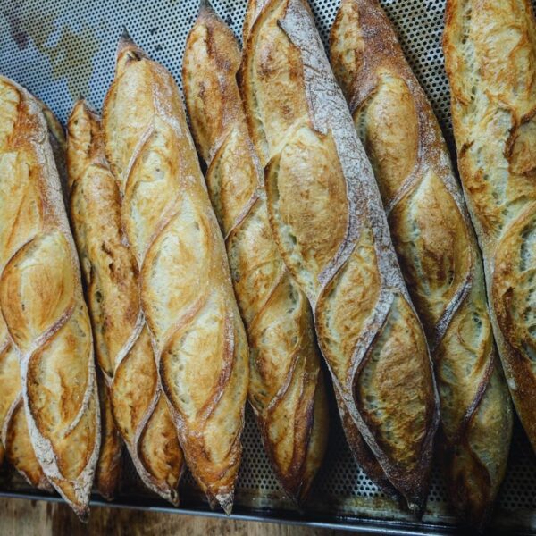 Ein Tablett mit Bio-Bio-Dinkel-Baguette auf einem Holztisch.