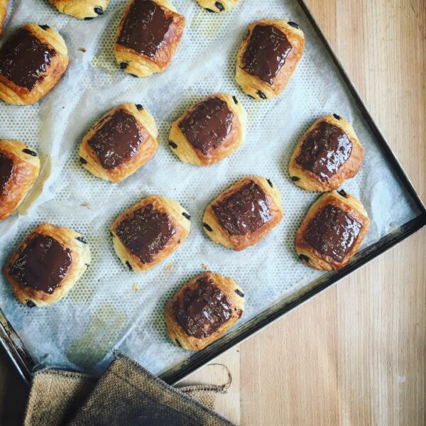 Pain_au_chocolat_Lund_sylt.jpg Deutsch-französisches Gebäck mit Schokolade auf einem Backblech